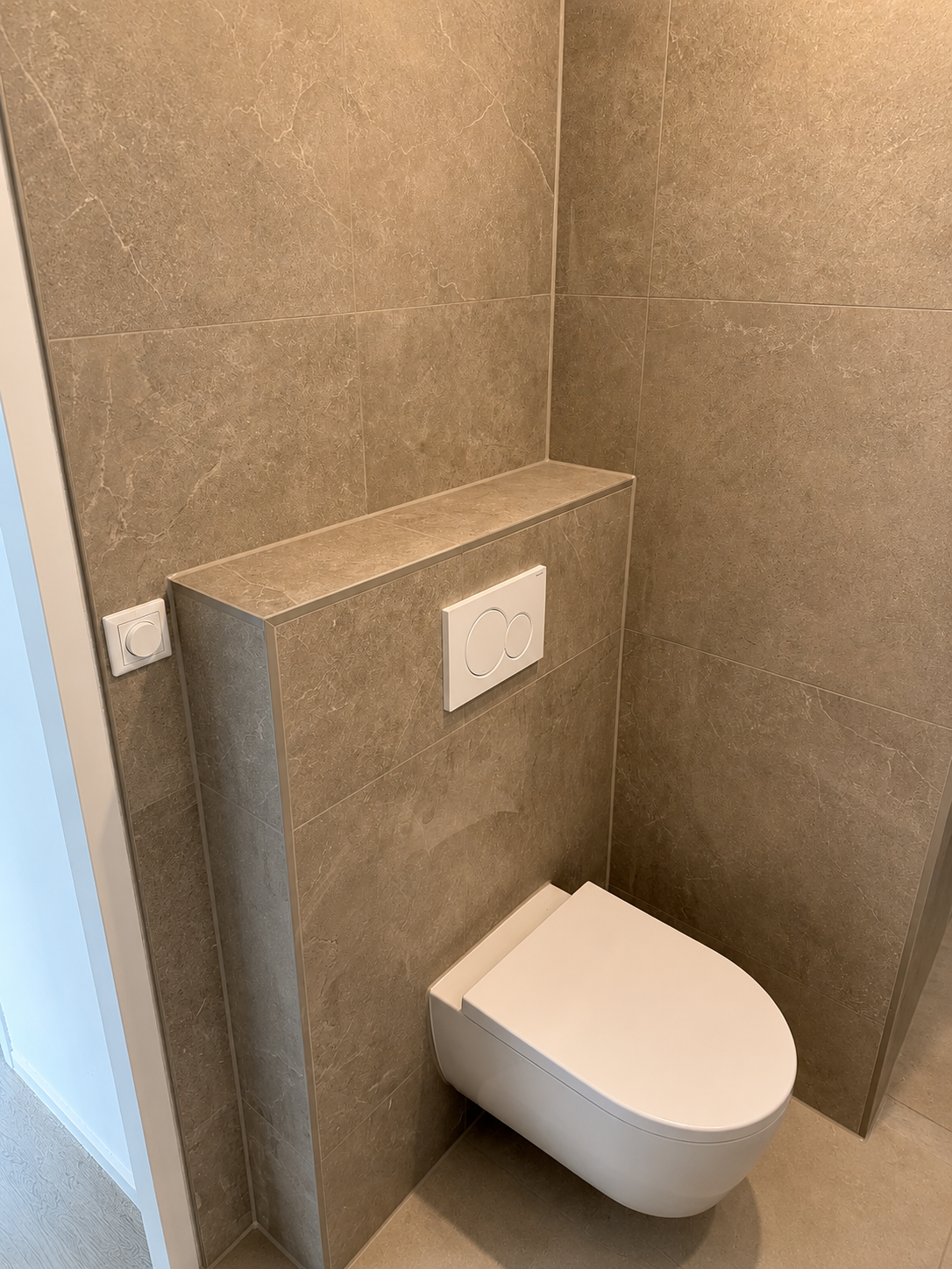 Wandcloset met volledig betegeld inbouwreservoir in natuursteenlook