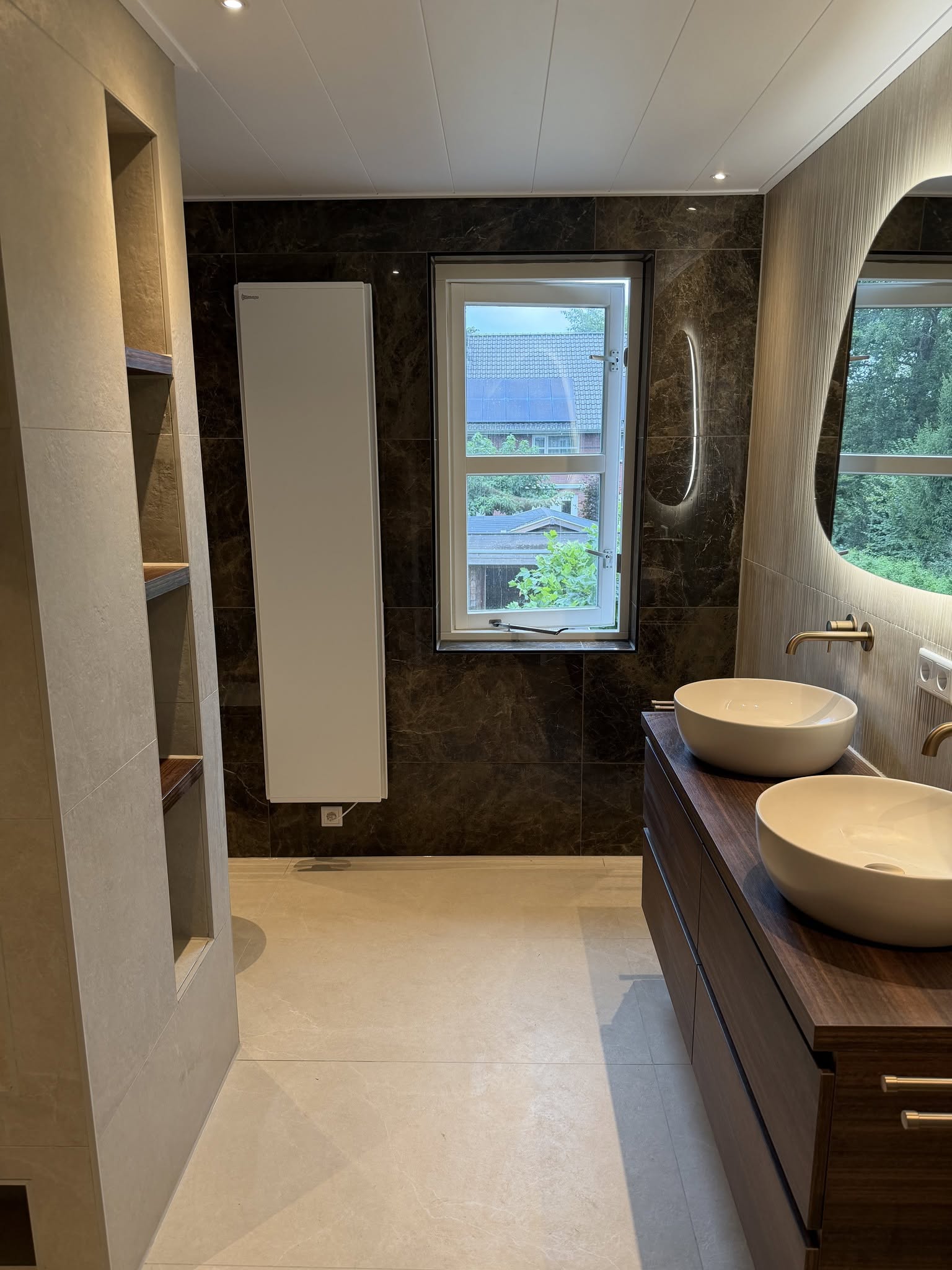 Complete badkamer met dubbel wastafelmeubel, donkere marmerlook wand en maatwerknissen