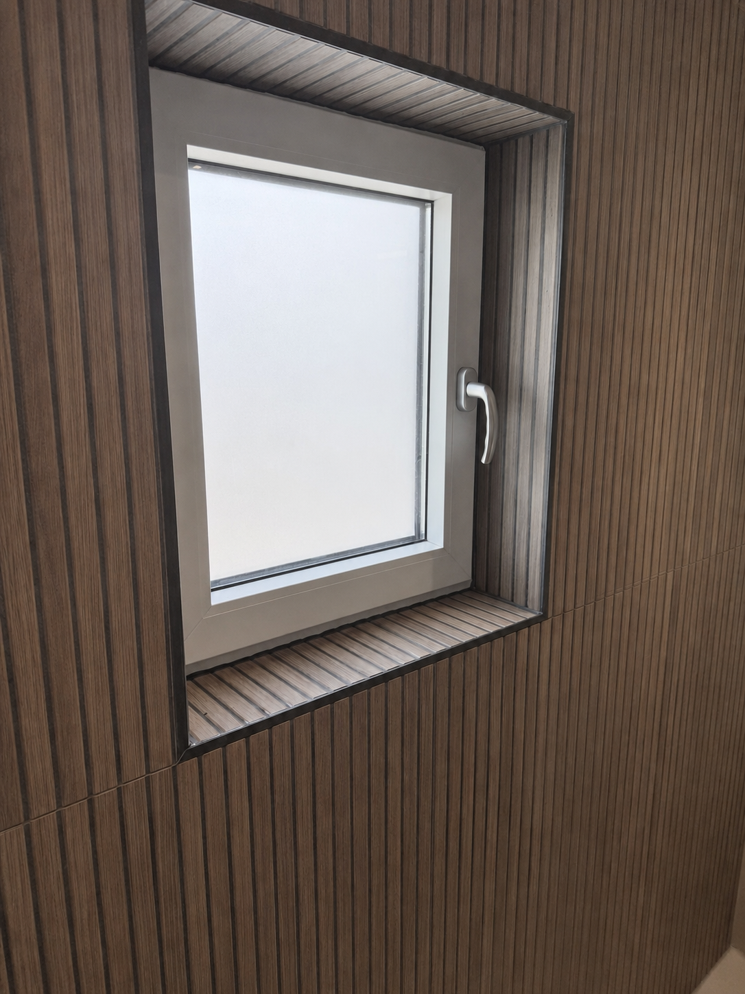 Betegelde raamnis met verticale houtlook tegels